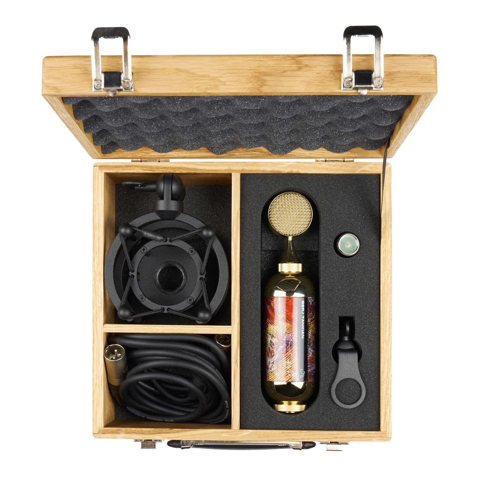 The microphone and accessories packed in the open oak carrying case
